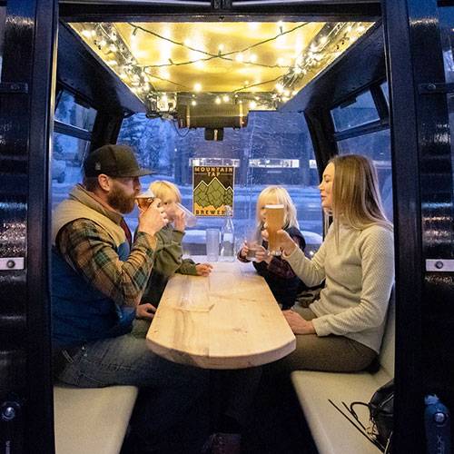 family enjoying beer in outdoor igloo at a brewery