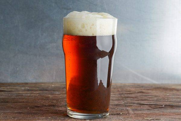 red-brown-colored beer in pint glass